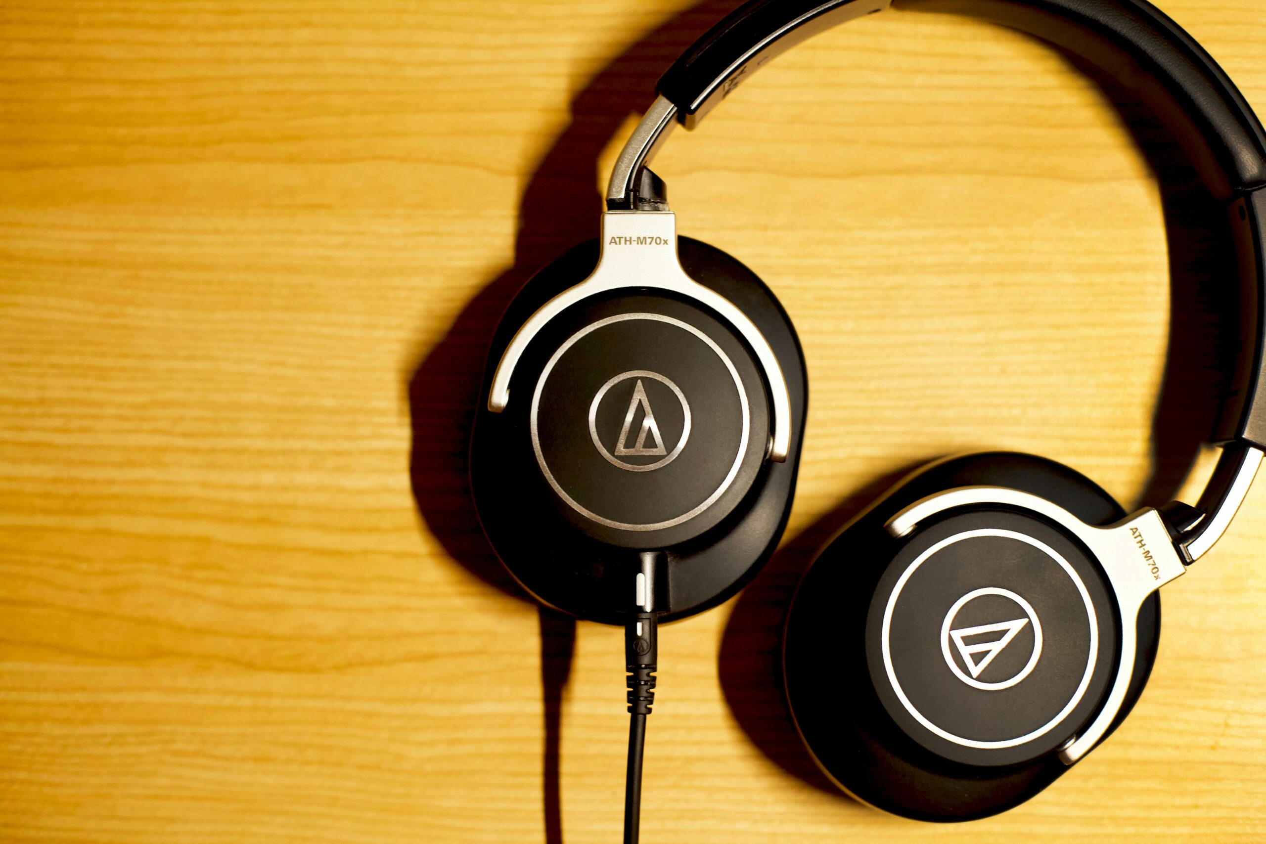 a pair of headphones sitting on top of a wooden table